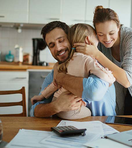 Parents hugging child
