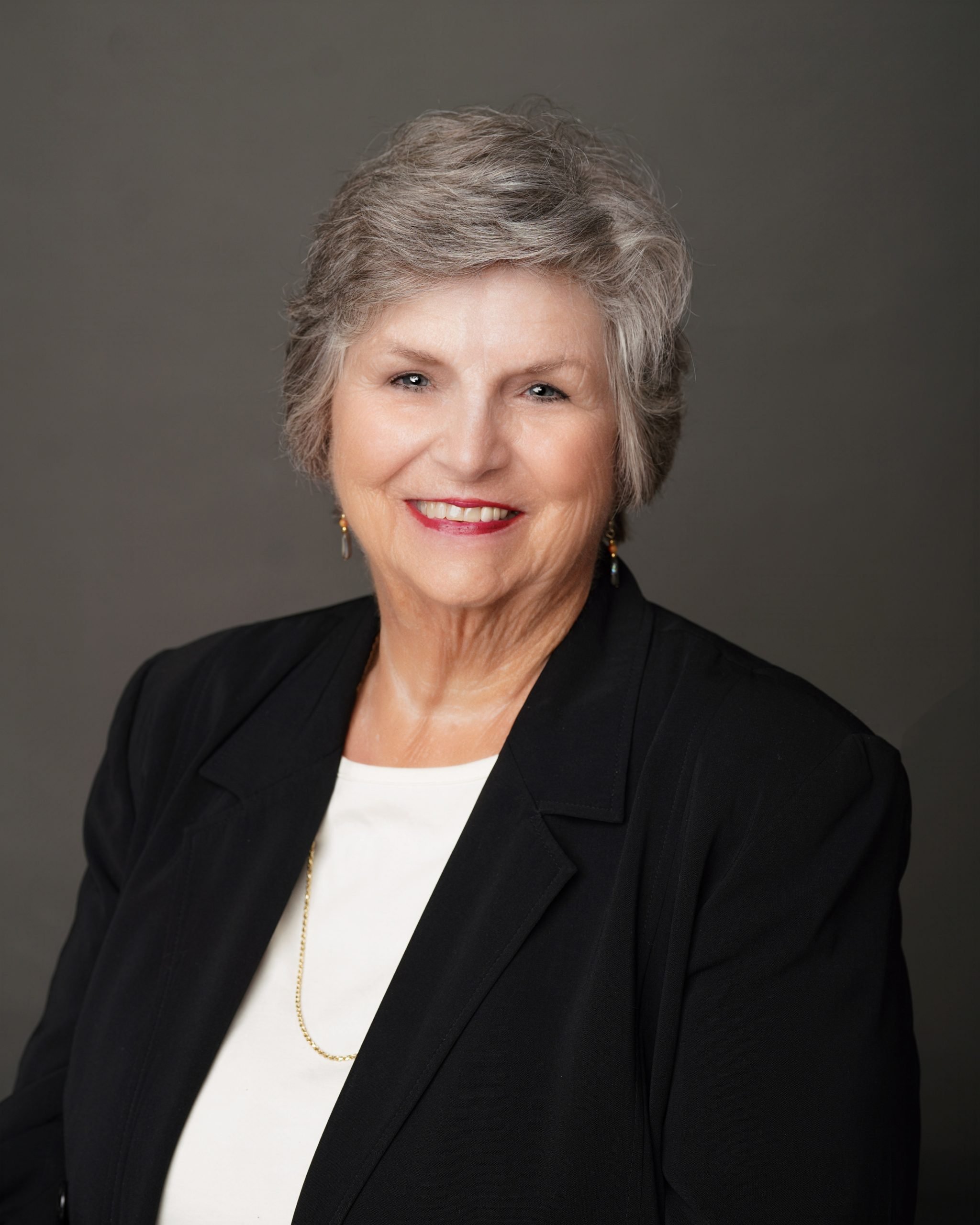 Professional headshot of senior woman in black blazer