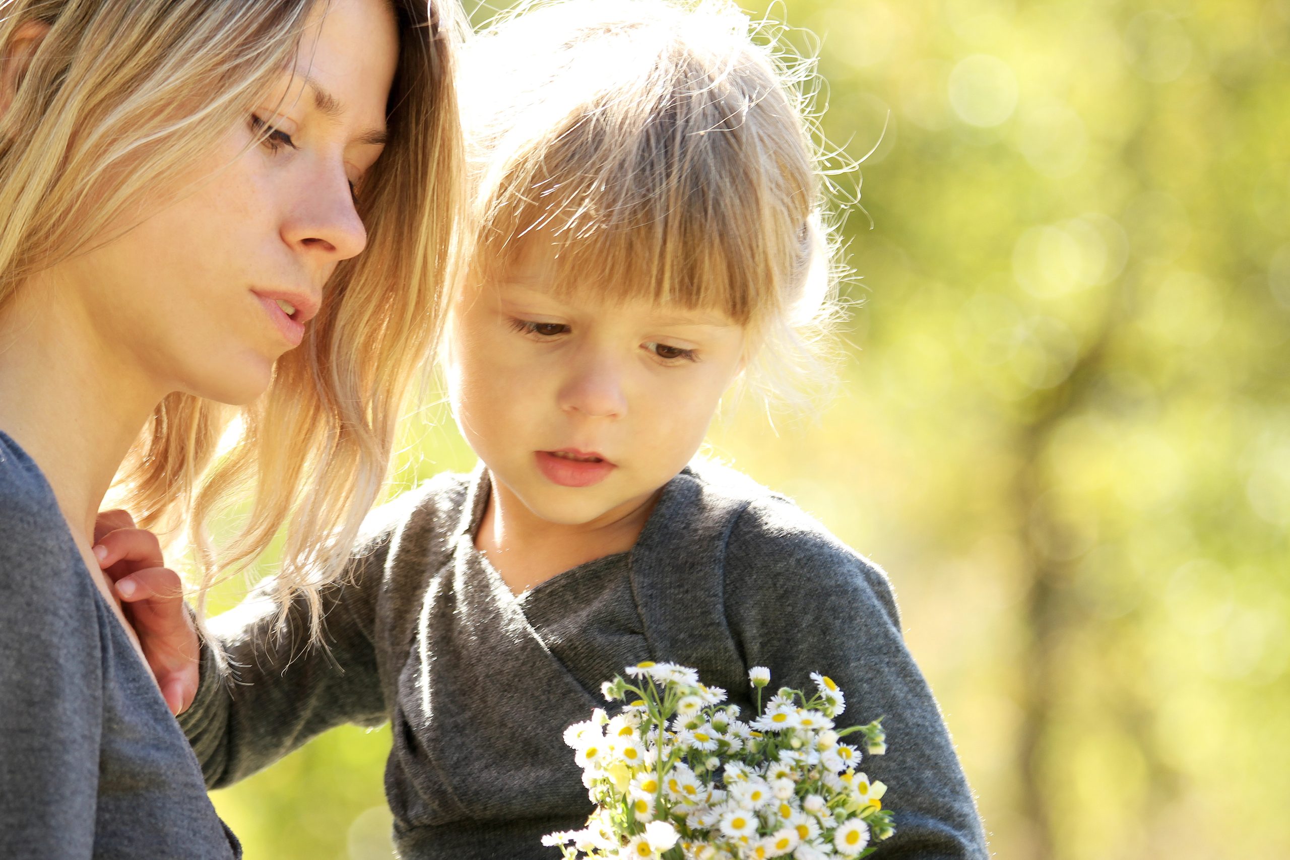 Mother holding young child outdoors