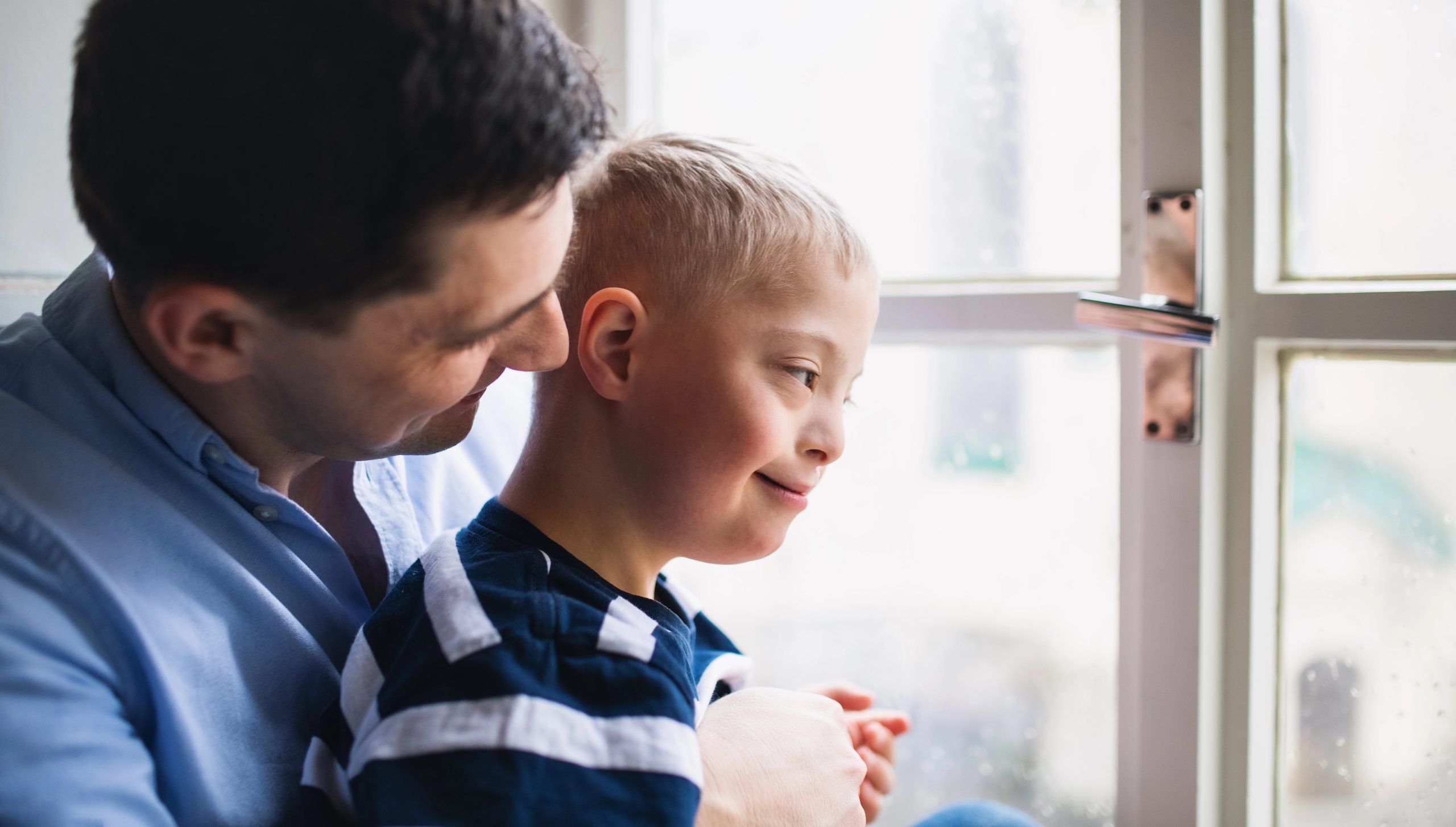 Adult and child looking out window together